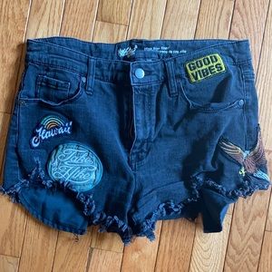 Black denim cutoff shorts with patches
